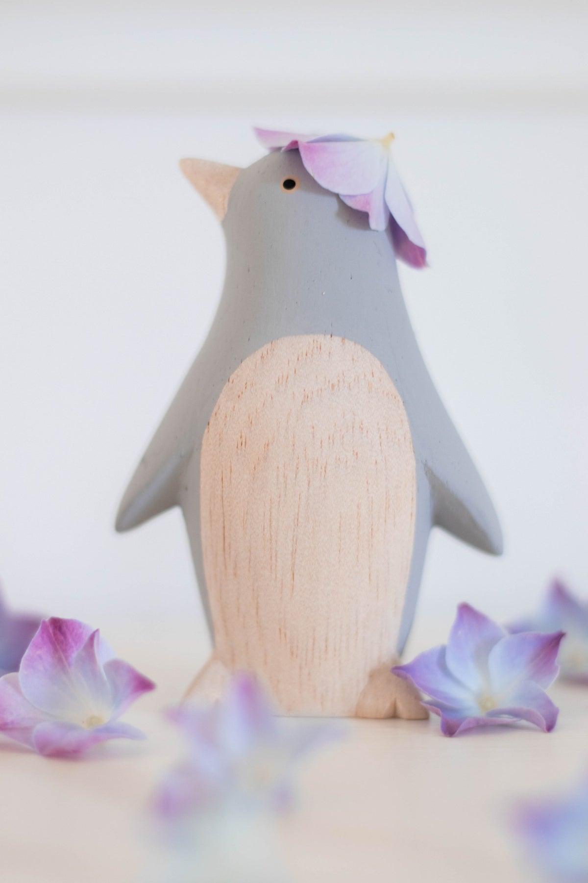 Figura de pingüino gris de madera ambientada